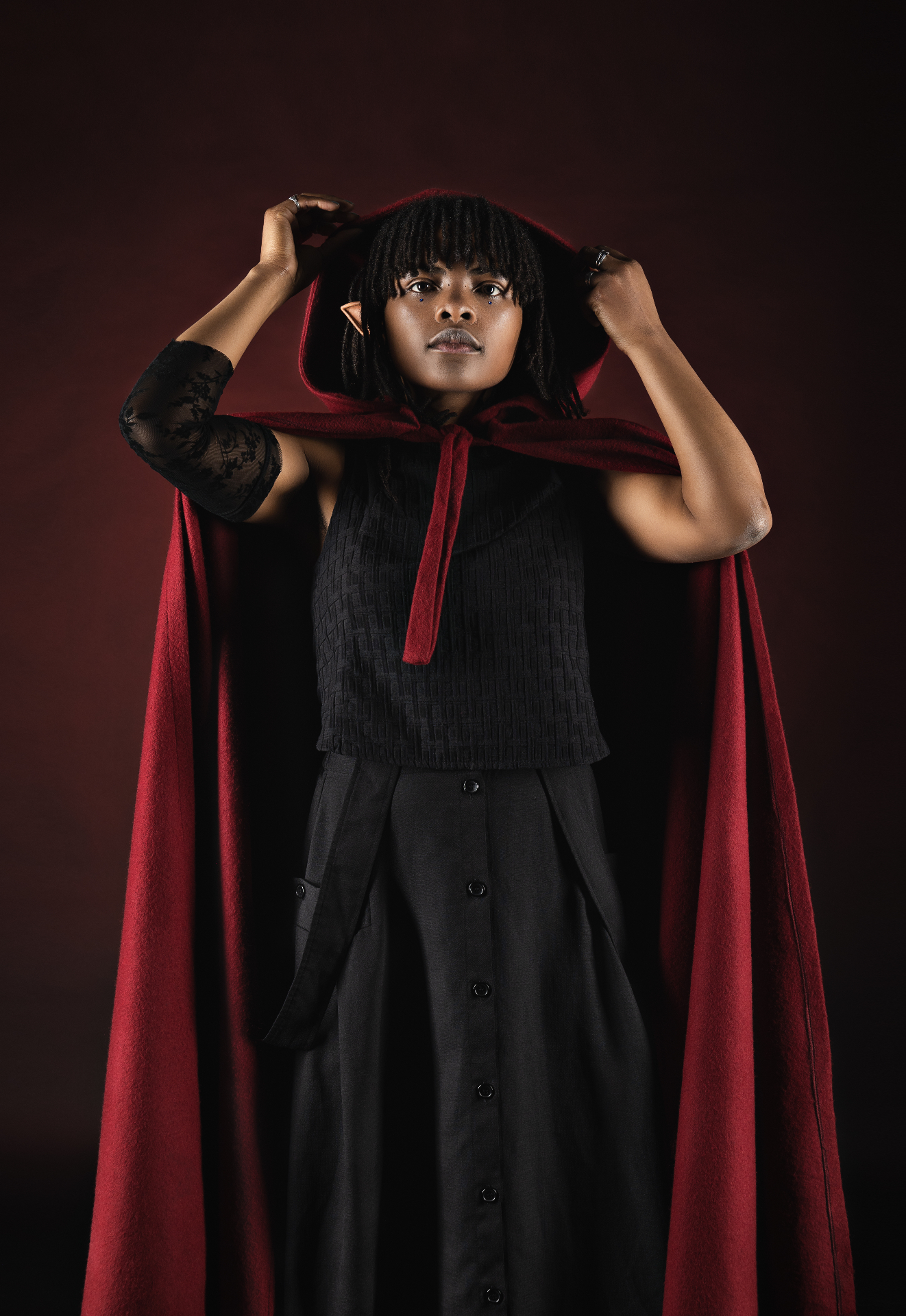 Daisee, geste artistique en cape rouge